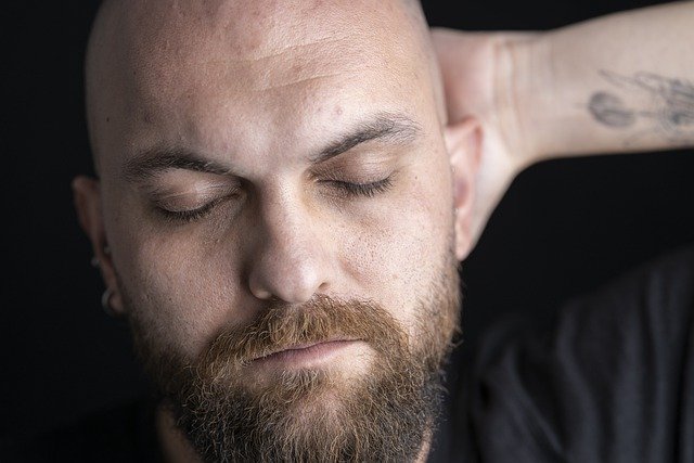 A man with his hand under his head is relieving stress by sleeping