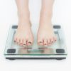 A pair of feet on a scale seeing the effects of weight loss from PIlates at MatWorkz Pilates