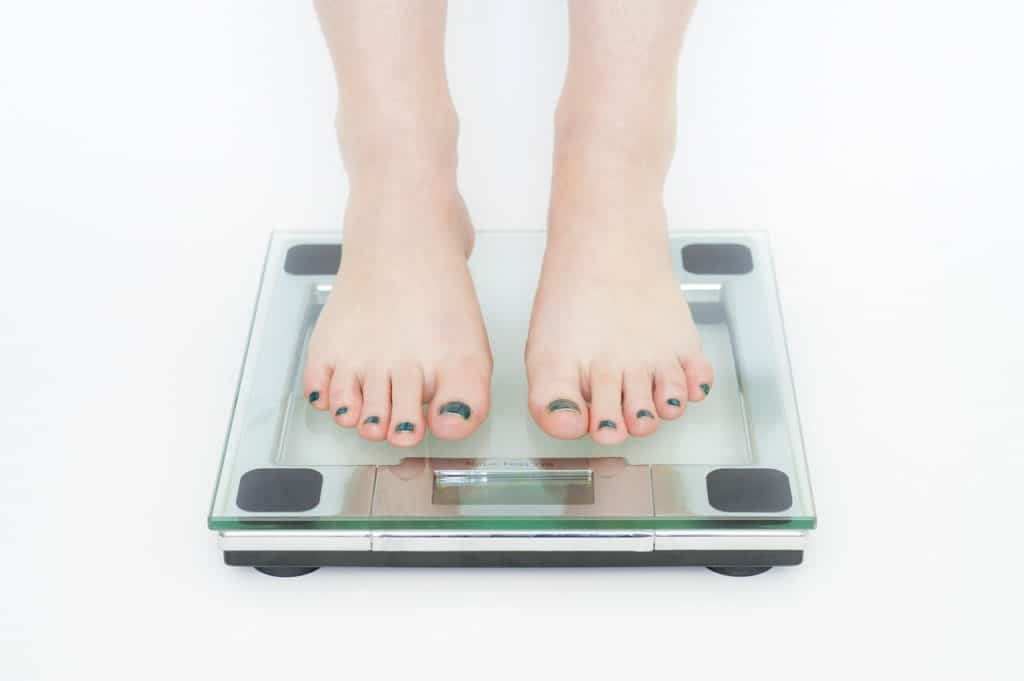 A pair of feet on a scale seeing the effects of weight loss from PIlates at MatWorkz Pilates