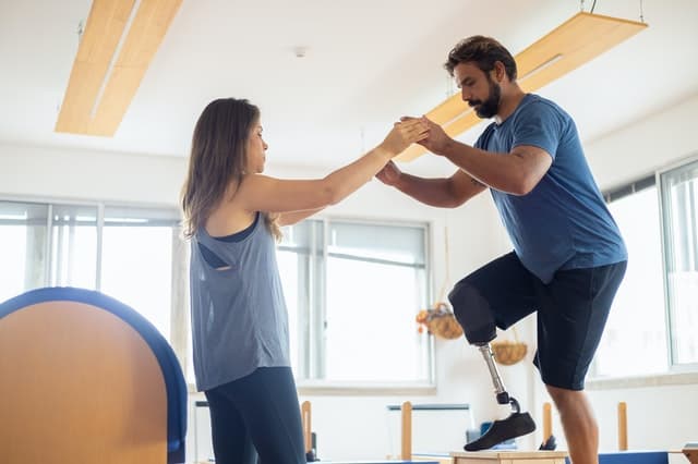 Client practices precision with instructor during Pilates