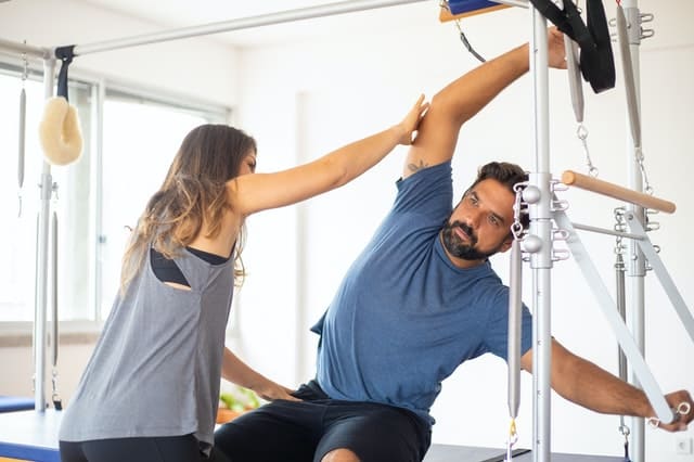 Practitioner is taught the basics of Pilates