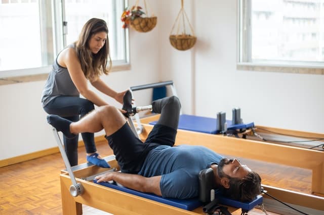 A student focuses on breath during Pilates practice with Instructor