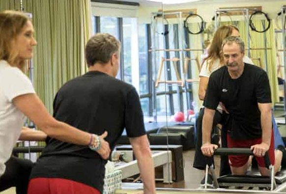 MatWorkz Pilates instructor working with client on Reformer Pilates